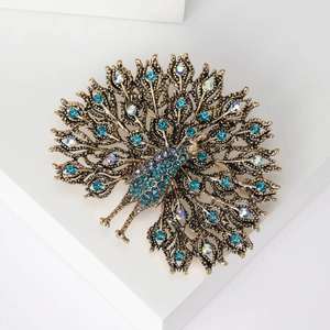 Close-up of vintage golden peacock brooch with sparkling blue and iridescent rhinestones