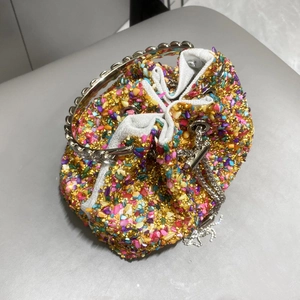 Top view of colorful rhinestone bucket bag with gold metal handle and drawstring detail
