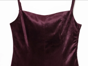 Detail of burgundy velvet dress neckline showing soft texture and premium fabric finish