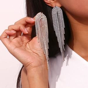 Close-up of dangling zircon tassel earrings in gold and silver plating on model