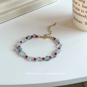 Dettaglio del bracciale con pietre acquamarina azzurre e perle tonde di agata rossa