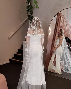 Detail of a white bridal veil with 3D floral appliques and pearls in mirror reflection