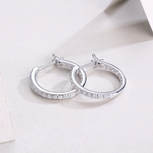 Macro shot of silver hoop earrings featuring double rows of micro-paved moissanite stones