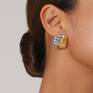 Two-tone gold and silver geometric square knot earrings shown on a model