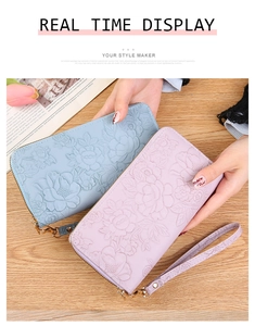 Detail of light blue and pink long wallets featuring elegant floral embossing and wrist straps
