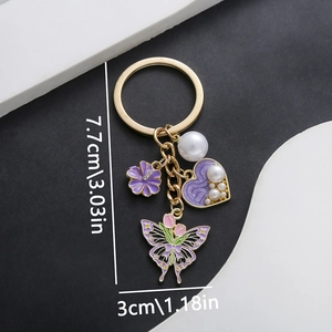 Detailed view of enamel butterfly and heart charms on a gold keychain with dimensions