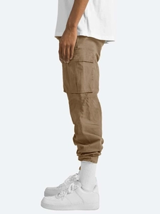 Detail view of large side cargo pocket and durable cotton fabric on brown trousers