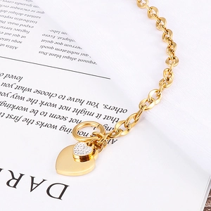 Golden chunky chain bracelet with heart pendants on an English book background