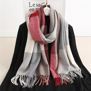 Detail of red and grey plaid cashmere scarf with soft fringes hanging on black top