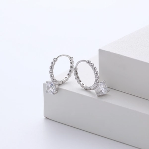 Elegant S925 sterling silver hoop earrings with cubic zirconia charms on white pedestal