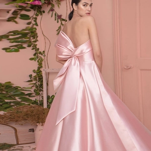 Elegant pink satin evening gown with strapless neckline and giant back bow detail