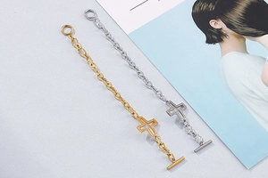Detail of gold and silver cross bracelets with OT buckle and sparkling zircon stones
