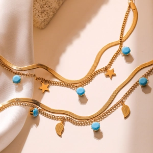 Double-layered gold chain bracelet with blue beads, star and leaf charms for women