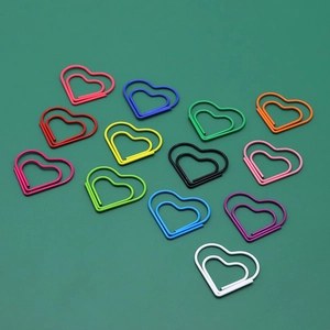 Colorful heart-shaped metal paperclips in various vibrant shades on a green background
