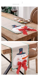 Detail of Christmas snowman linen table runner with 3D bow and green striped edging
