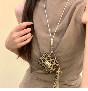 Close-up of a leopard print mini bag pendant with a beige leather strap and gold clasp