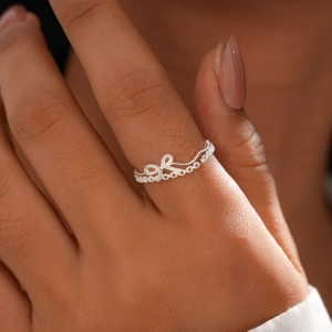 Detail of an open silver crown ring with cubic zirconia micro-pave setting on finger