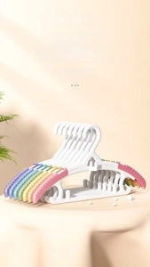Detail of baby clothes hangers featuring colorful non-slip rainbow shoulder pads and white frame