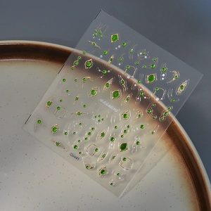 Luxe green gemstone nail stickers with gold line patterns on transparent backing, model Co-441