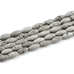 Close-up of oval lava stone beads with natural pores and metallic silver gray coating