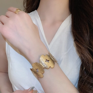 Detail of elegant gold butterfly leaf open ring and matching cuff bracelet set