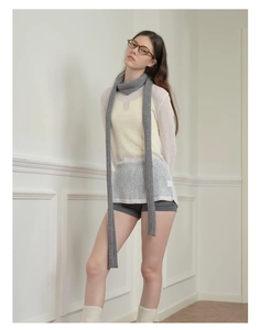 Gray long thin knit scarf draped on a model for a trendy millennial winter outfit