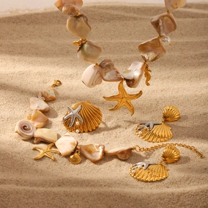 Golden starfish pendant necklace and shell jewelry set displayed on a sunny beach background