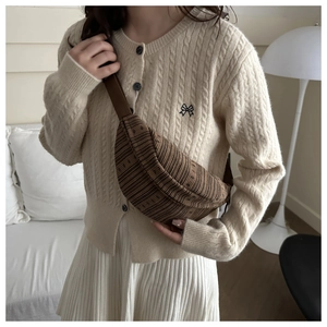 Detail of dark brown corduroy crossbody chest bag with vertical striped texture and zipper
