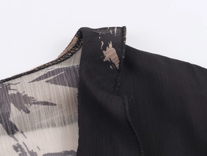 Detail of shoulder seam showing black fabric and abstract brushstroke chiffon print