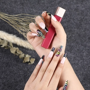 Long coffin press-on nails with black leaf patterns and pink French tips on grey felt