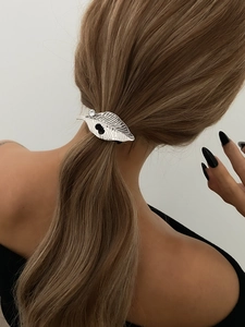 Detail of silver leaf hair clip with rhinestone on golden blonde ponytail