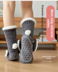 Detail of grey knit slipper socks featuring anti-slip silicone grippers and faux fur trim