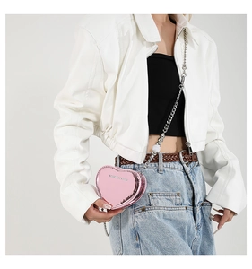 Detail of pink laser heart bag featuring shiny finish and elegant metal chain strap