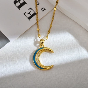 Macro view of golden crescent moon necklace with blue enamel and zircon inlay detail