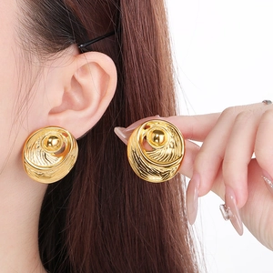 Close-up of geometric 18k gold plated stainless steel earrings on a model's ear