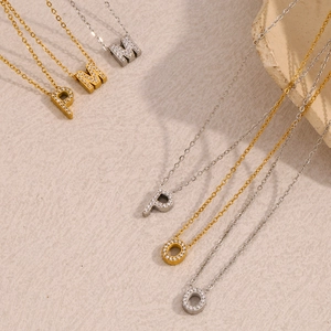 Dettaglio dei ciondoli con lettere in oro 18K e argento con zirconi incastonati