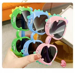 Detailed close-up of colorful dinosaur-themed kids sunglasses in green blue and pink colors