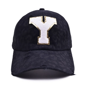 Detail of baseball cap with plush letter Y, gold glitter edges and distressed mesh back