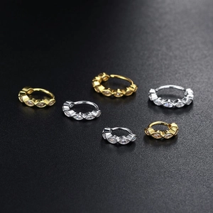 Detailed close-up of gold and silver hoop earrings with marquise-cut marquise stones