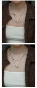 Detail of vintage double-layer necklace with pearls, tiger eye beads and zircon pendant