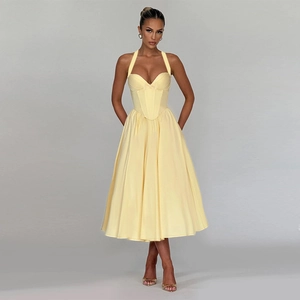 Detail of light yellow halter neck dress showing corset waist and flowy A-line skirt fabric