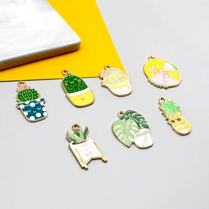 Set of 7 gold-plated enamel plant charms including cactus, monstera leaf and pineapple