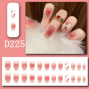 Detail of long ballerina press-on nails with pink gradient and white 3D bow charms