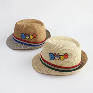 Detailed macro view of woven straw sun hats for children with striped ribbon and cartoon patch