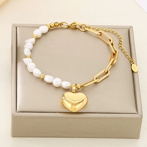 Détail du bracelet coeur en perles dorées avec pendentif acier sur boîte cadeau