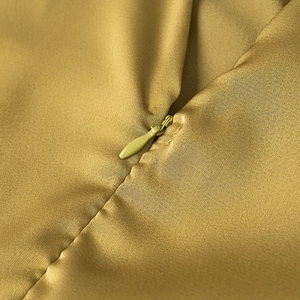 Close-up of invisible zipper detail on high-quality ginger yellow satin slip dress