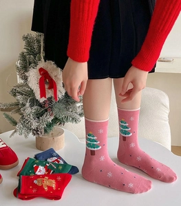 Detailed view of pink Christmas socks with tree patterns and colorful festive holiday stockings