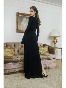 Close-up of black long-sleeve dress featuring a high side slit and elegant slim-fit tailoring