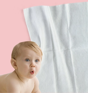 Detail view of textured white cotton soft baby wipe on pink background with infant