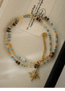 Close-up of beaded necklace with gold star pendant and colorful tiger eye stones